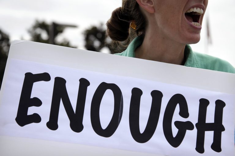 This Oct. 2, 2013, file photo shows Vicki Maturo, of Culver City, Calif., as she protests against the government shutdown outside the federal building in Los Angeles.