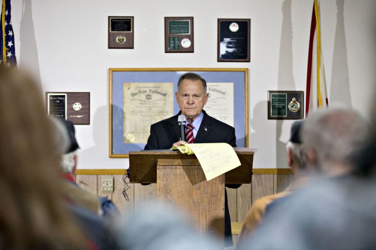 Moore Tries to Play to the Crowd While Avoiding Cameras at Rally
