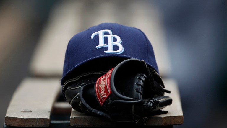 The hat and glove of an unidentified player for the Tampa Bay Rays sits on the dugout step.