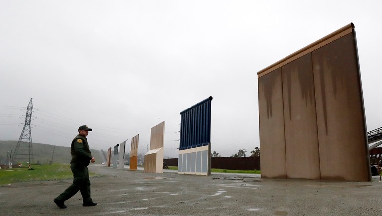 Border Patrol agent Vincent Pirro walks towards prototypes for a border wall.