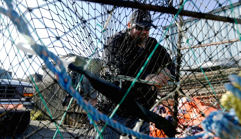 Geoff Bettencourt, owner of the fishing boat Moriah Lee, demonstrates how he sets up a black cod trap in his yard in Half Moon Bay, Calif.