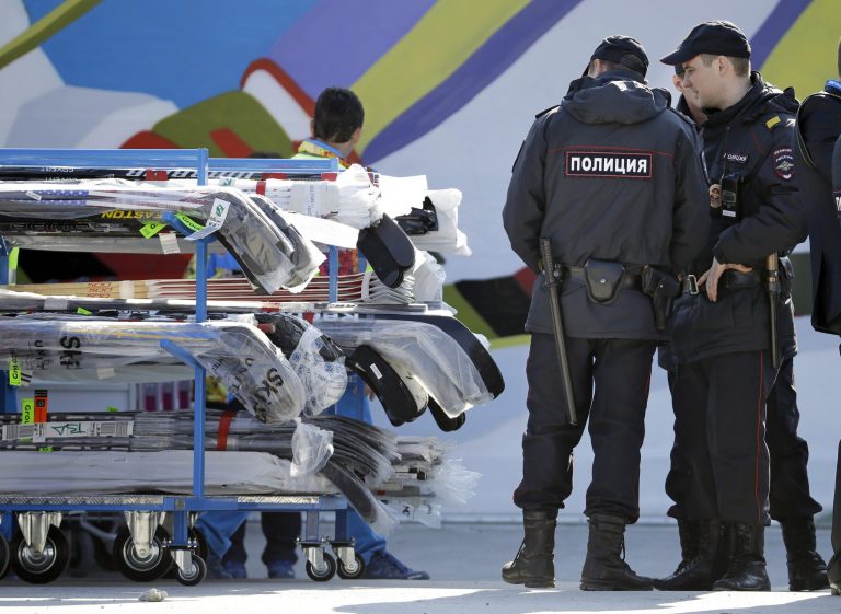 FILE - In this Feb. 10, 2014 file photo, police officers look over a cart of hockey sticks after they were taken off a plane as NHL hockey players arrive at the Sochi International Airport for the 2014 Winter Olympics, in Sochi, Russia.Sochi hotel guests are walking, unchecked, past unused metal detectors. Security guards are no longer poking around at the pockets and ankles of every single person entering Olympic facilities. Tangerines and bottles of Coke are making it through security barriers that banned them two weeks ago. For all the warnings that security in Sochi would be invasive and aggressive, it's appearing more uneven, and in places almost relaxed.  (AP Photo/Mark Humphrey, File)