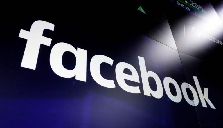 A list of settlements, violations and breaches scrolls over Facebook's logo on a screen as David Marcus, CEO of Facebook's Calibra digital wallet service, foreground, appears before a House Financial Services Committee hearing on Facebook's proposed cryptocurrency on Capitol Hill in Washington, Wednesday, July 17, 2019.