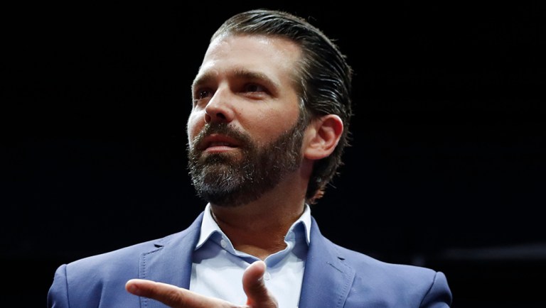 Donald Trump Jr. points to his phone during a rally.