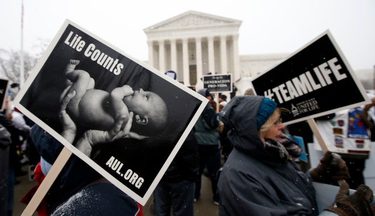 Signs are carried during the March for Life in front of the Supreme Court in D.C.