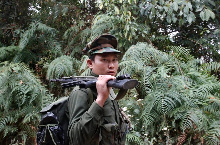 In this March 17, 2018, photo, a Kachin Independence Army fighter walks along a jungle path from the Mu Du front line toward Hpalap outpost in an area controlled by the Kachin rebels in northern Kachin state, Myanmar. A government air strike on a KIA/KIO celebration killed dozens of people, most of them civilians, in the deadliest single action since the military coup in February 2021. (AP Photo/Esther Htusan, File)