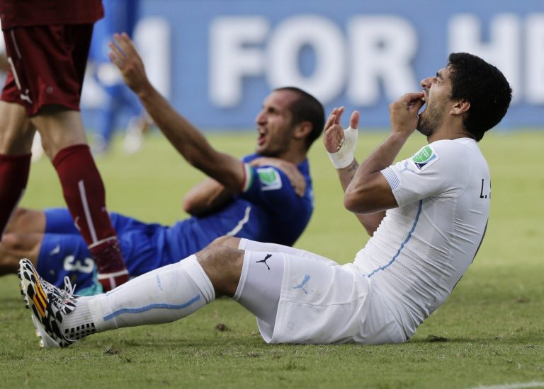 10ThingstoSeeSports - Uruguay's Luis Suarez holds his teeth after running into Italy's Giorgio Chiellini's shoulder during the group D World Cup soccer match between Italy and Uruguay at the Arena das Dunas in Natal, Brazil, Tuesday, June 24, 2014. (AP Photo/Ricardo Mazalan, File)