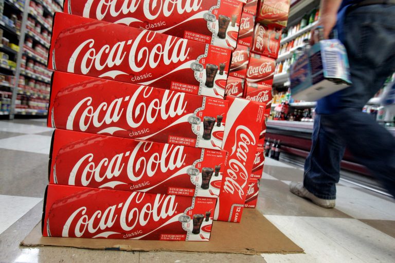   FILE- In this April 20, 2009, file photo, a customer walks by cases of Coca-Cola at JJ&F Market in Palo Alto, Calif. Coca-Cola, the world's biggest soft drink maker said Thursday, June 14, 2012, it will start doing business in Myanmar as soon as the U.S. government issues a license allowing American companies to make such investments, the first time in 60 years. (AP Photo/Paul Sakuma, file)  