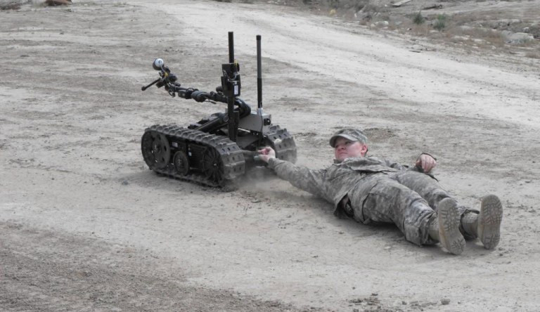 While being dragged, 225th Engineer Brigade Soldier Sgt. Kasandra Deutsch of Pineville, La., demonstrates the power of the Talon robot, April 15, 2009 during a training exercise with the 9th Iraqi Army Engineer Regiment.