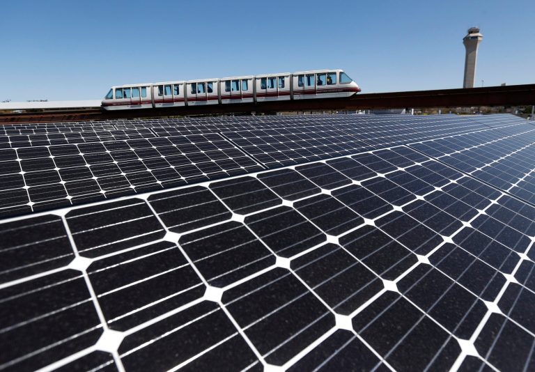 Solar panels that were recently placed on the roof of the building supplying energy to the AirTrain at Newark Liberty International Airport are seen as the train rolls by last month.(AP Photo/Julio Cortez)