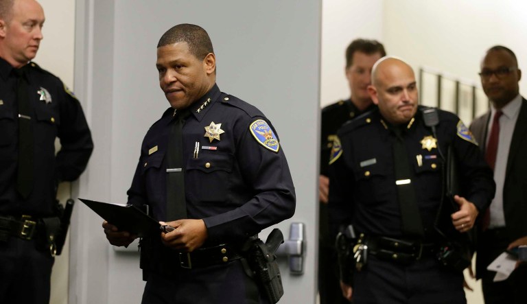 San Francisco Police Chief William Scott, foreground, walks to the podium at a news conference, Tuesday, May 21, 2019, in San Francisco. Police agreed to return property seized from a San Francisco journalist in a raid, but the decision did little to ease tensions in the case, which has alarmed journalism advocates and put pressure on city leaders. Authorities have said the May 10 raids on freelancer Bryan Carmody's home and office were part of an investigation into what police called the illegal leak of a report on the death of former Public Defender Jeff Adachi, who died unexpectedly in February.