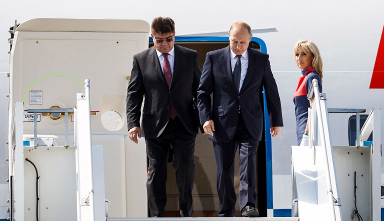 Russia's new ambassador to Finland Pavel Kuznetsov, left, escorts Russian President Vladimir Putin as he disembarks the plane at Helsinki. 