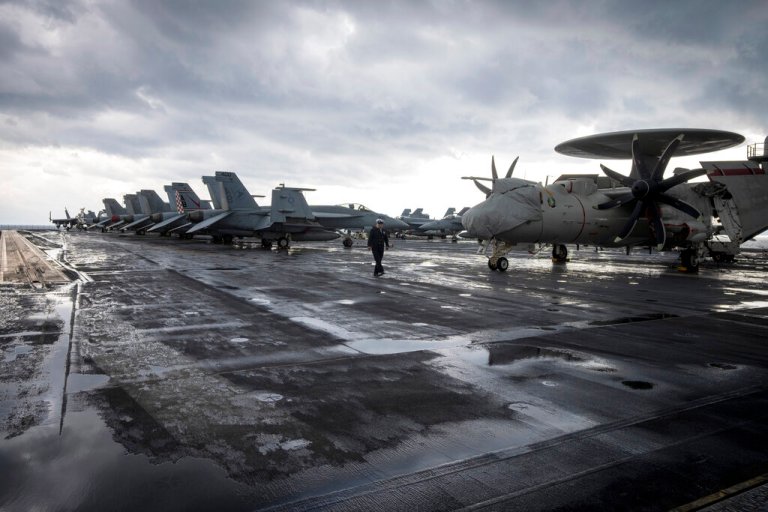 A naval officer walks on a deck at the aircraft carrier USS Harry S. Truman, near Split, Croatia, Monday, Feb. 14, 2022.