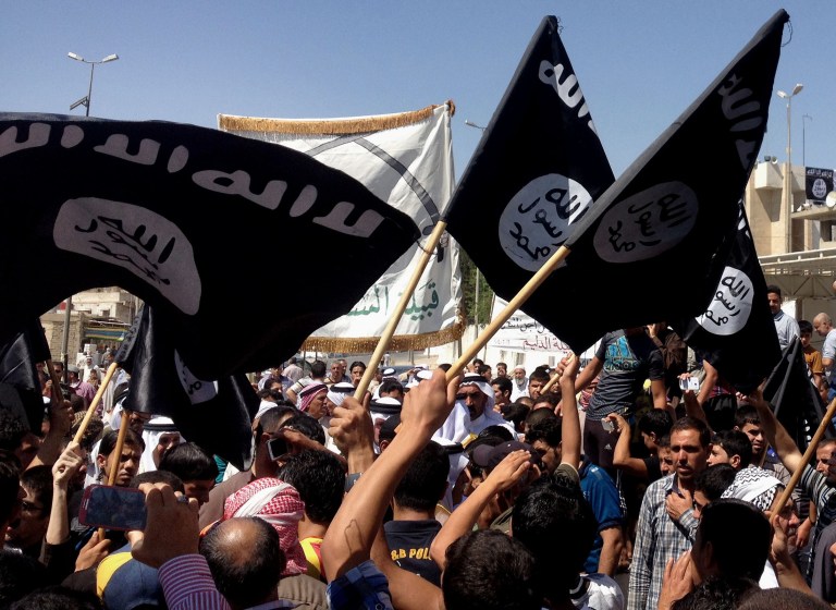Demonstrators chant pro-Islamic State group slogans as they wave the group's flags in front of the provincial government headquarters in Mosul, Iraq. (AP Photo, File)