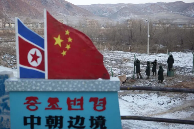Saturday, Dec. 8, 2012, photo where Chinese paramilitary policemen build a fence near a concrete marker depicting the North Korean and Chinese national flags with the words 