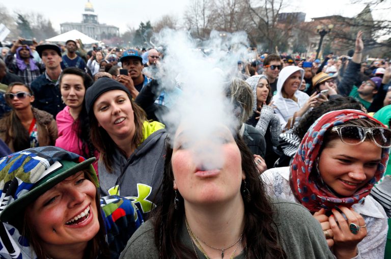 Partygoers dance and smoke marijuana on the first of two days at the annual 4/20 marijuana festival in Denver.