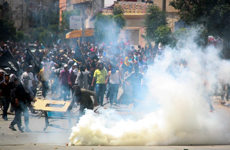 Radical Islamist movement Ansar al-Shariah supporters clash with Tunisian police officers after Tunisia's Interior Ministry on Friday banned their annual conference supposed to be held in Kairouan, in Ettadhamen, near Tunis, Sunday May 19, 2013. Massive numbers of Tunisian police and army surrounded Tunisia's religious center of Kairouan to prevent a conference by a radical Islamist movement that has been implicated in attacks around the country. (AP Photo/Nawfel)