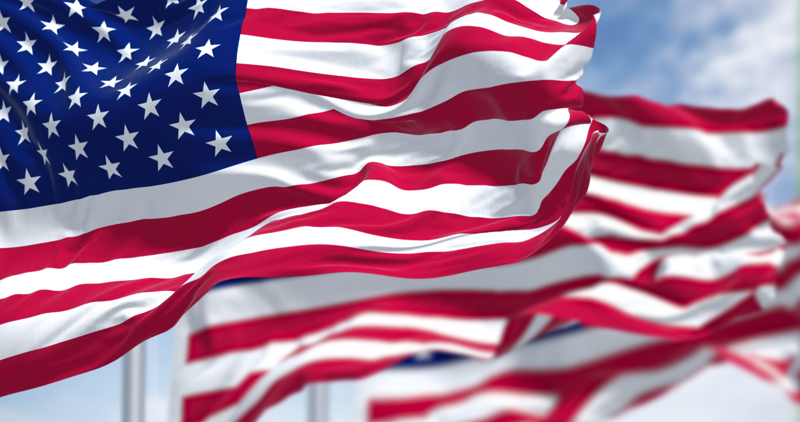 Three flags of the United States of America waving in the wind