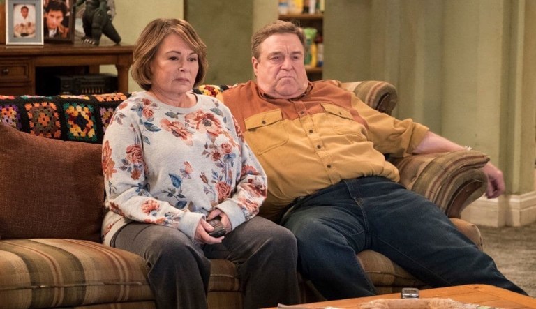 In this image released by ABC, Roseanne Barr, left, and John Goodman appear in a scene from the reboot of "Roseanne." The Nielsen company said viewership for the show's premiere shot up to 25 million people when you count people who watched the three days after last Tuesday's premiere. Never before has a show gained that many viewers via time shifting within three days.