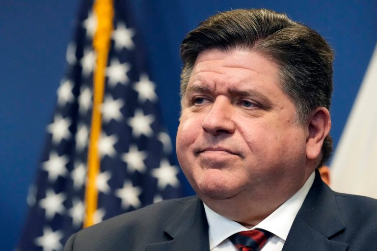 Illinois Gov. JB Pritzker stands in front of an American flag.