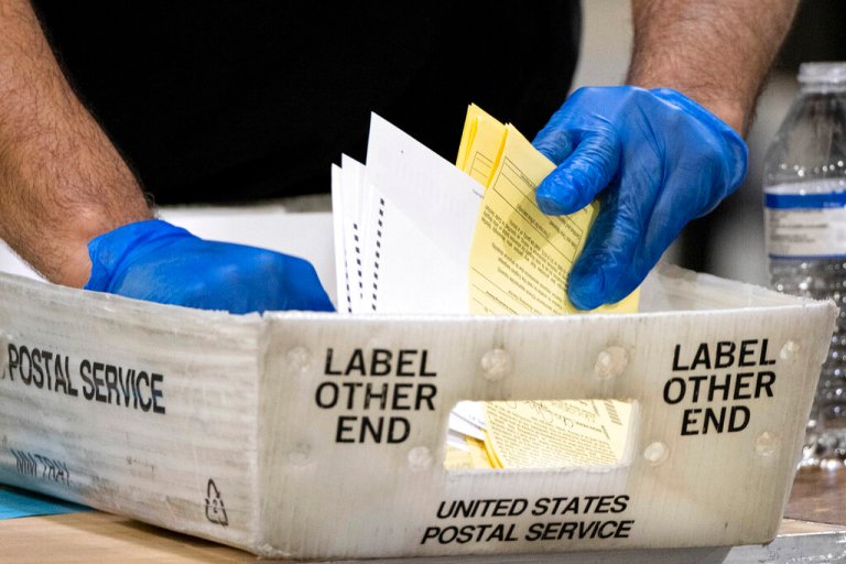 FILE - In this Jan. 5, 2021, file photo, Fulton County, Georgia, elections workers process absentee ballots for the Senate runoff election in Atlanta. The seeds of misinformation about next week's 2022 midterm elections were planted in 2020. That's when baseless conspiracy theories about the presidential election took root and festered, helping to spur the Jan. 6, 2021, attack on the Capitol. Despite efforts by tech companies to slow their spread, misleading claims about mail ballots, vote tallying, and certification never went away. (AP Photo/Ben Gray, File)