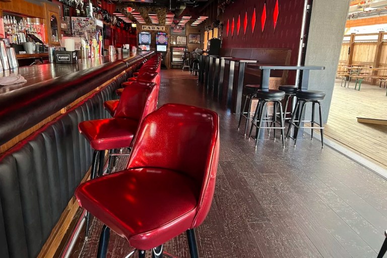 Empty stools line a bar.