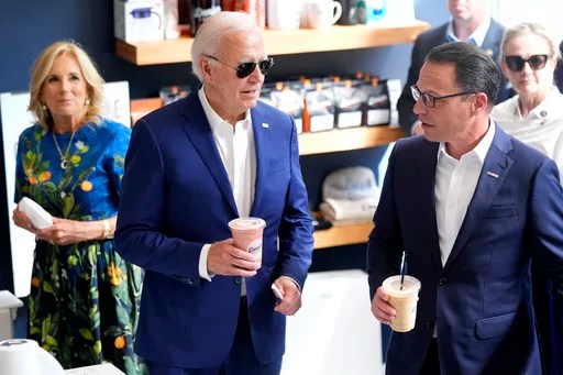 President Joe Biden and Gov. Josh Shapiro (D-PA) talk while holding coffee with first lady Jill Biden in the background.