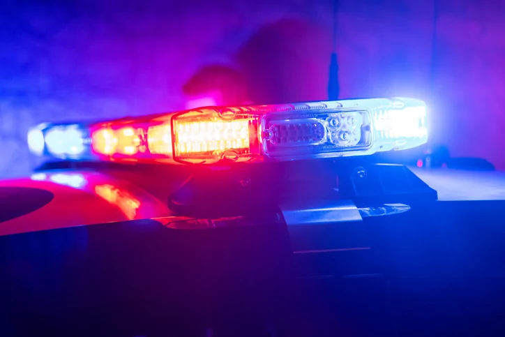 Police car with flashing red and blue lights.