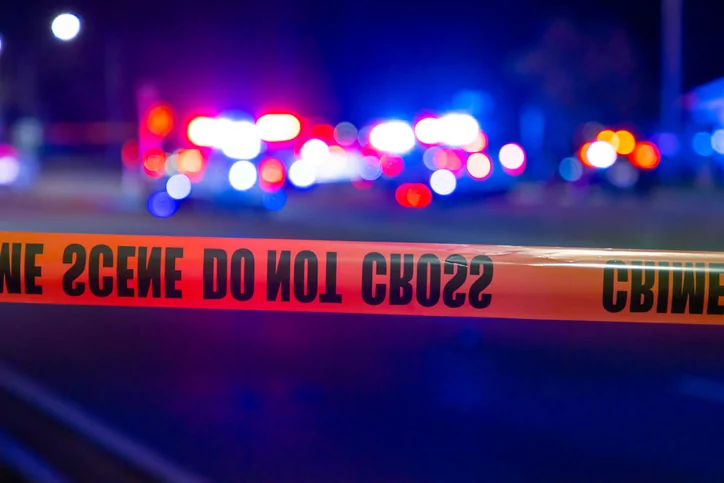 Police lights and tape during a crime scene at night.