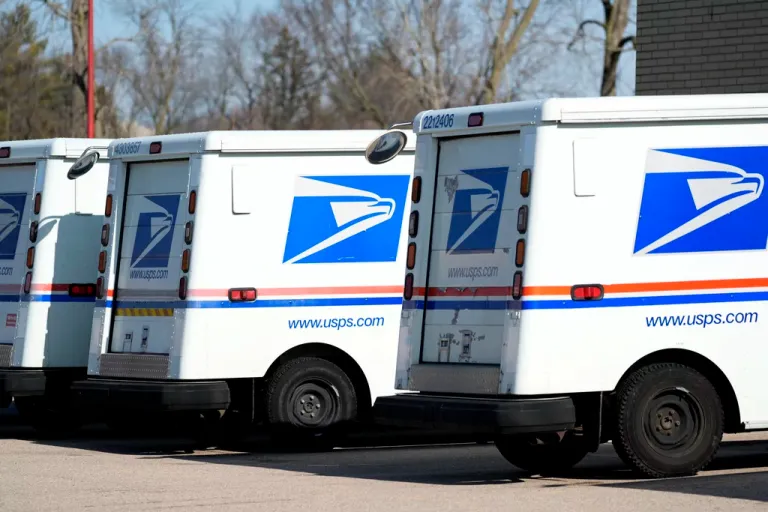 U.S. Postal Service trucks park outside a post office in Wheeling, Illinois, Monday, Jan. 29, 2024.
