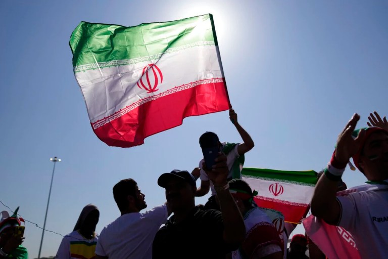 Supporters wave Iranian flags.