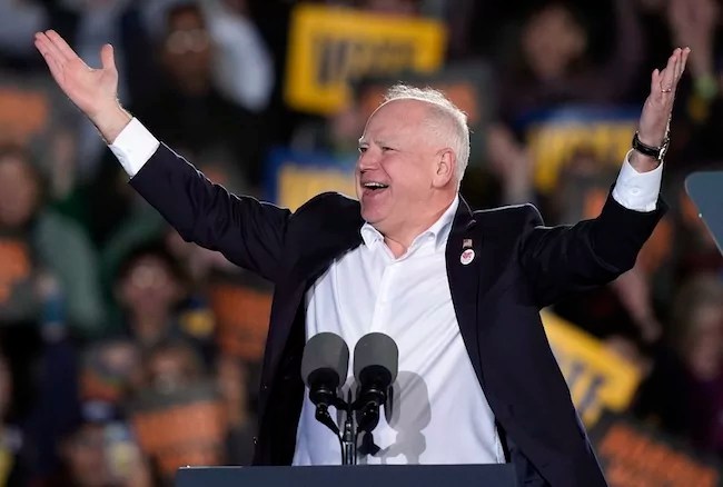 Gov. Tim Walz (D-MN) raises his arms in front of a crowd.