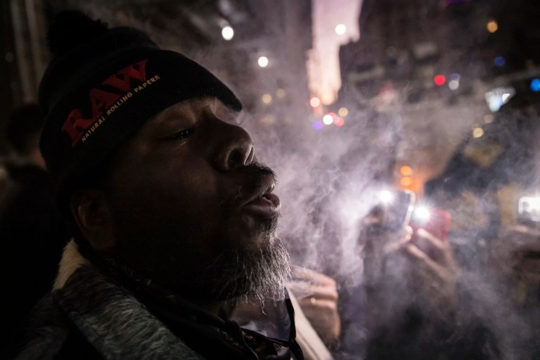 A person exhales while smoking marijuana outside the Housing Works Cannabis Co., New York's first legal cannabis dispensary, at 750 Broadway in Noho.