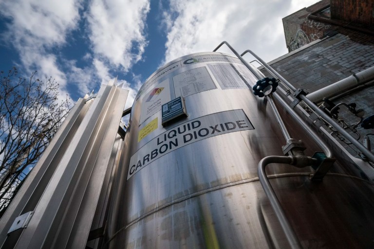 A liquid carbon dioxide containment unit stands outside the fabrication building of Glenwood Mason Supply Company, April 18, 2023, in the Brooklyn borough of New York.