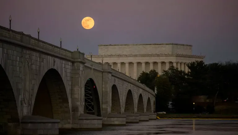 The full Moon, also known in January as the Wolf Moon, rises above the Lincoln Memorial and the Memorial Bridge, Monday, Jan. 13, 2025, as seen from Arlington, Virginia.