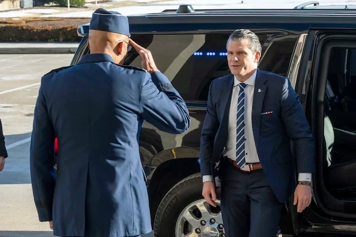Defense Secretary Pete Hegseth, center, is welcomed to the Pentagon by Chairman of the Joint Chiefs of Staff Gen. Charles Q. Brown Jr., Monday, Jan. 27, 2025 in Washington