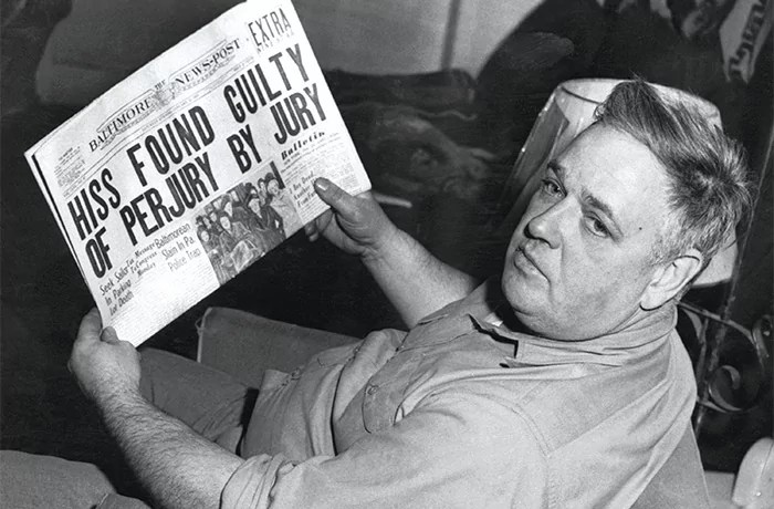 Whittaker Chambers reads the headline documenting the conviction of Alger Hiss.