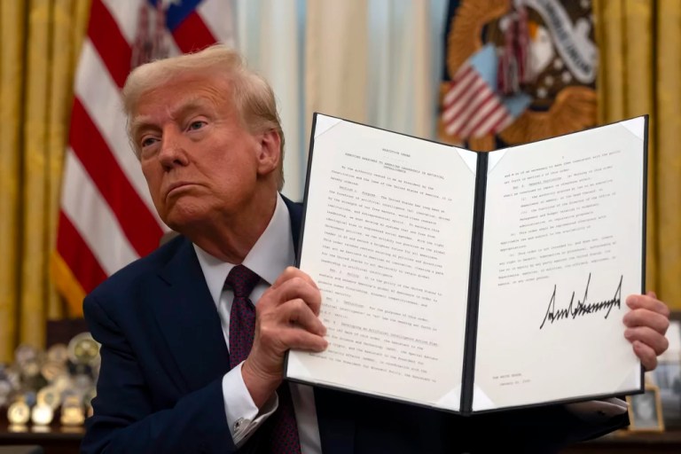 President Donald Trump holds up a signed executive order relating to AI in the Oval Office of the White House, Thursday, Jan. 23, 2025, in Washington. (AP Photo/Ben Curtis)