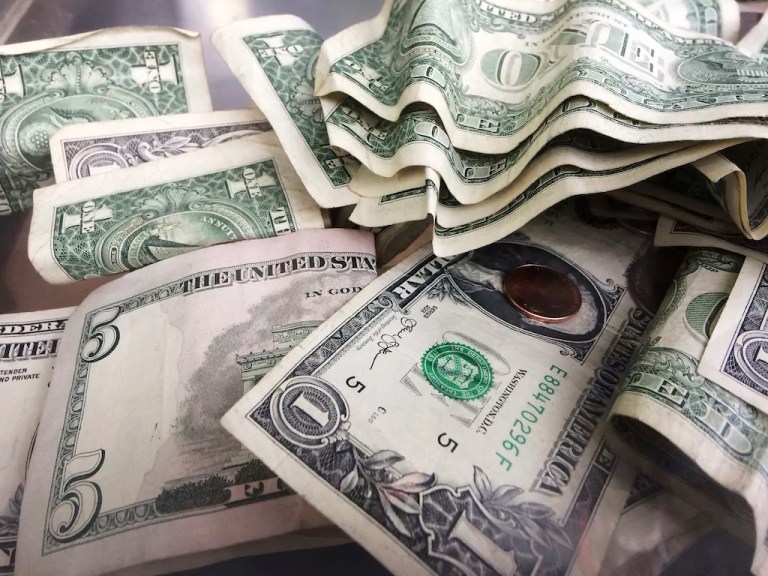 A tip jar contains $1 and $5 bills