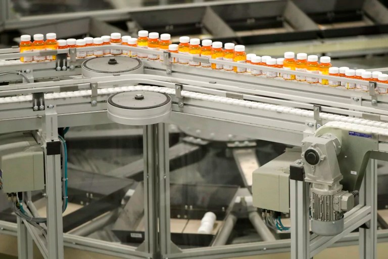 In this July 10, 2018, file photo, bottles of medicine ride on a belt at the Express Scripts mail-in pharmacy warehouse in Florence, New Jersey.