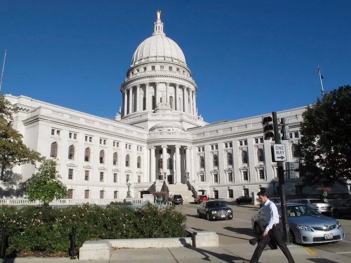 A man walks by the Wisconsin Capitol, Oct. 10, 2012, in Madison.