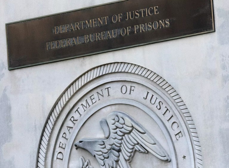 A sign for the Federal Bureau of Prisons is displayed