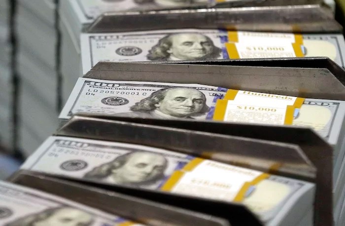 Freshly cut stacks of $100 bills make their way down the line at the Bureau of Engraving and Printing Western Currency.