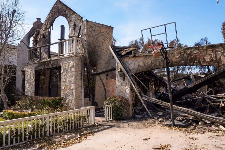 A basketball is stuck in the net outside of a residence destroyed by the Palisades Fire in the Pacific Palisades neighborhood of Los Angeles, Friday, Jan. 24, 2025.
