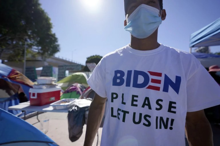 A Honduran man seeking asylum in the United States wears a shirt that reads, 