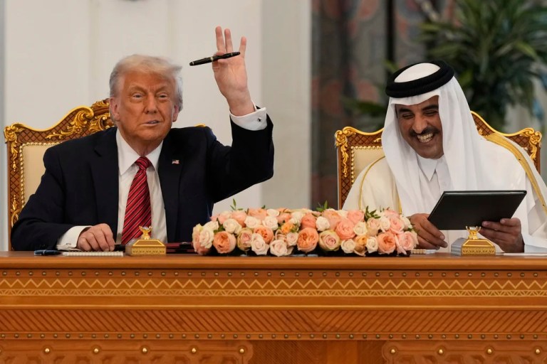 President Donald Trump holds up a pen given by Qatar's Emir Tamim bin Hamad Al Thani as they exchange documents during a signing ceremony at the Amiri Diwan in Doha, Qatar, Wednesday, May 14, 2025.