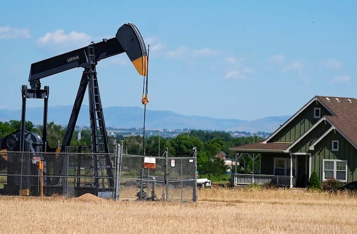 GDP - A pumpjack works on a pad near a housing development July 4, 2024, in Dacono, Colo.