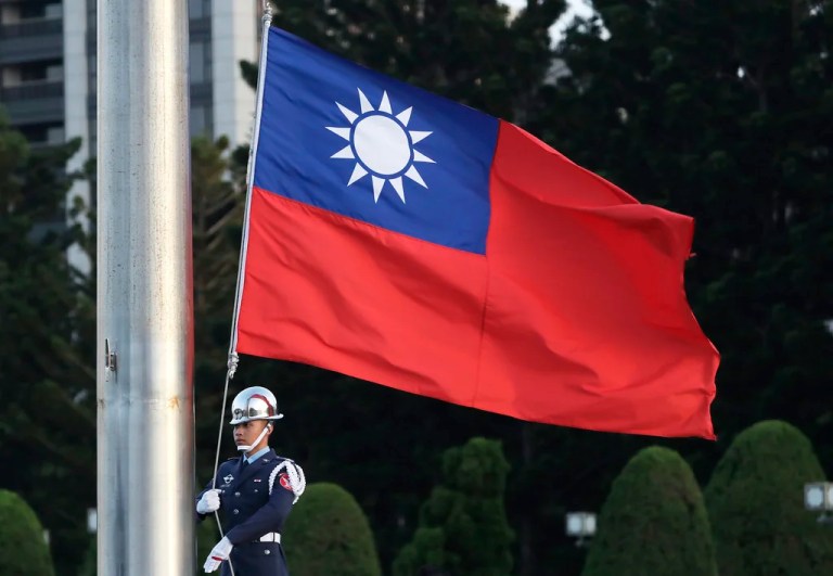 A soldier lowers the Taiwanese national flag.