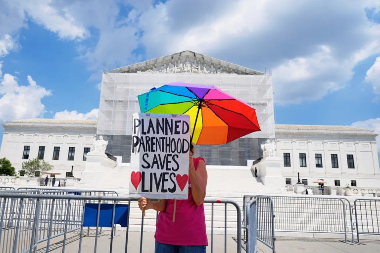 A protester stands outside of the Supreme Court, Thursday, June 26, 2025, in Washington.