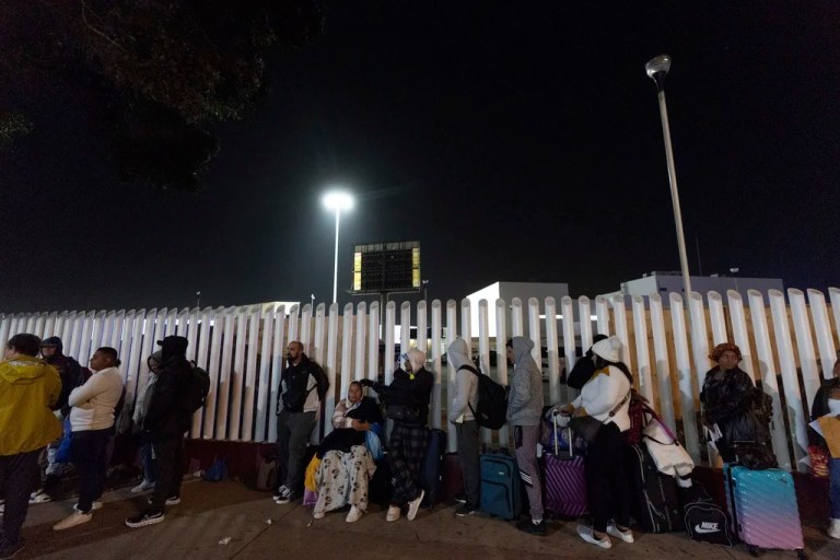 FILE - Migrants from Cuba and Venezuela line up at a Mexican immigration checkpoint as they make their way across the border for appointments to legally apply for asylum in the United States, on Nov. 5, 2024, in Tijuana, Mexico. (AP Photo/Gregory Bull, File)